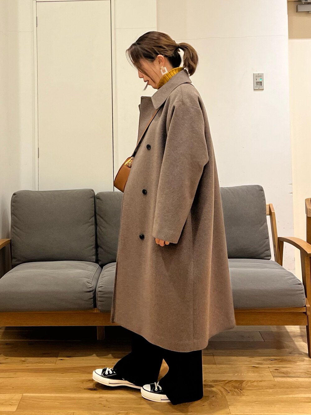 ブラウン系のその他アウター、イエロー系のニット/セーター、ブルー系のデニムパンツを着用したレディースの冬コーディネートの2枚目の写真