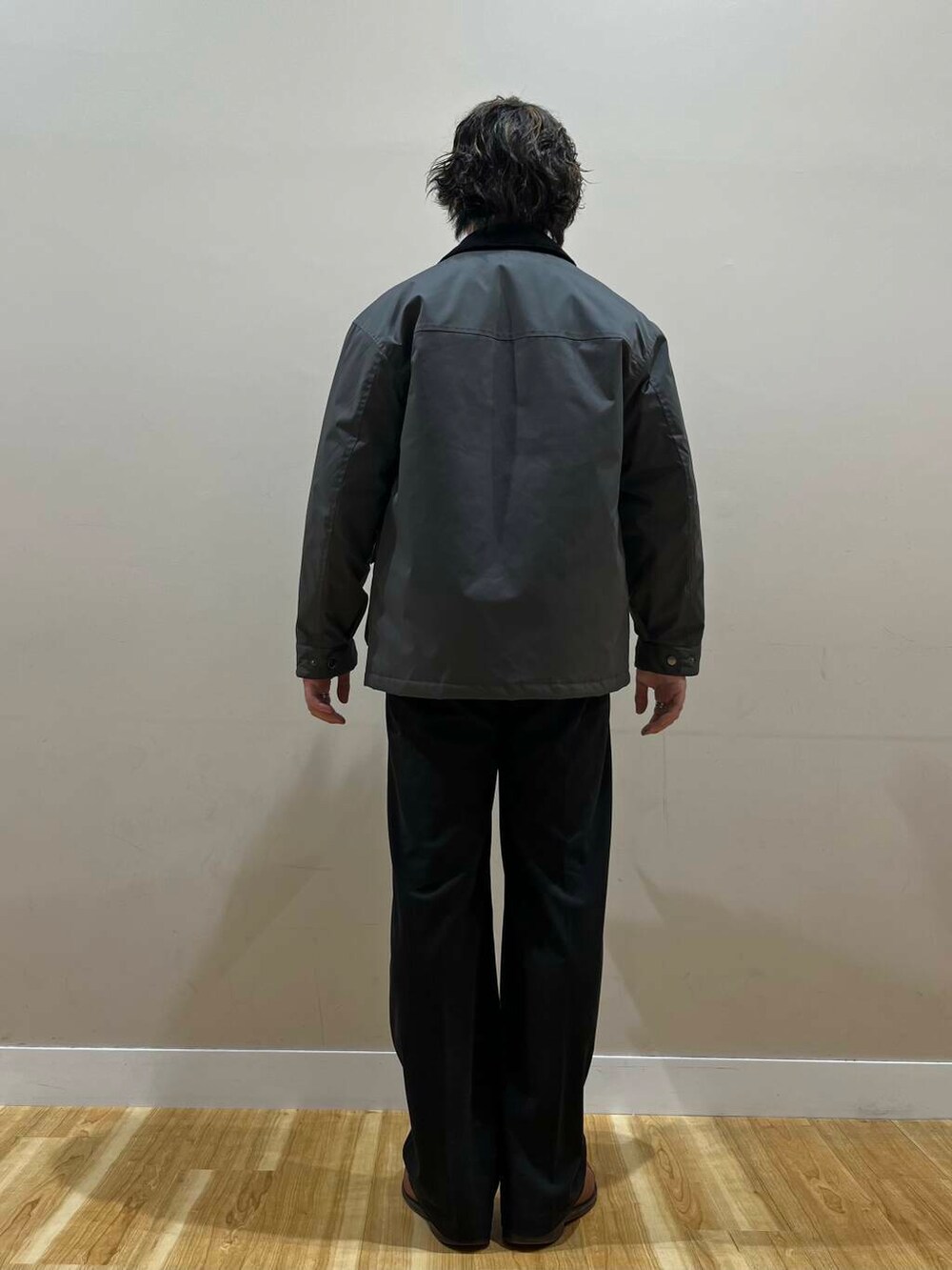 グリーン系のニット/セーター、グレー系のその他アウター、ブラック系のその他パンツを着用したメンズの秋コーディネートの2枚目の写真