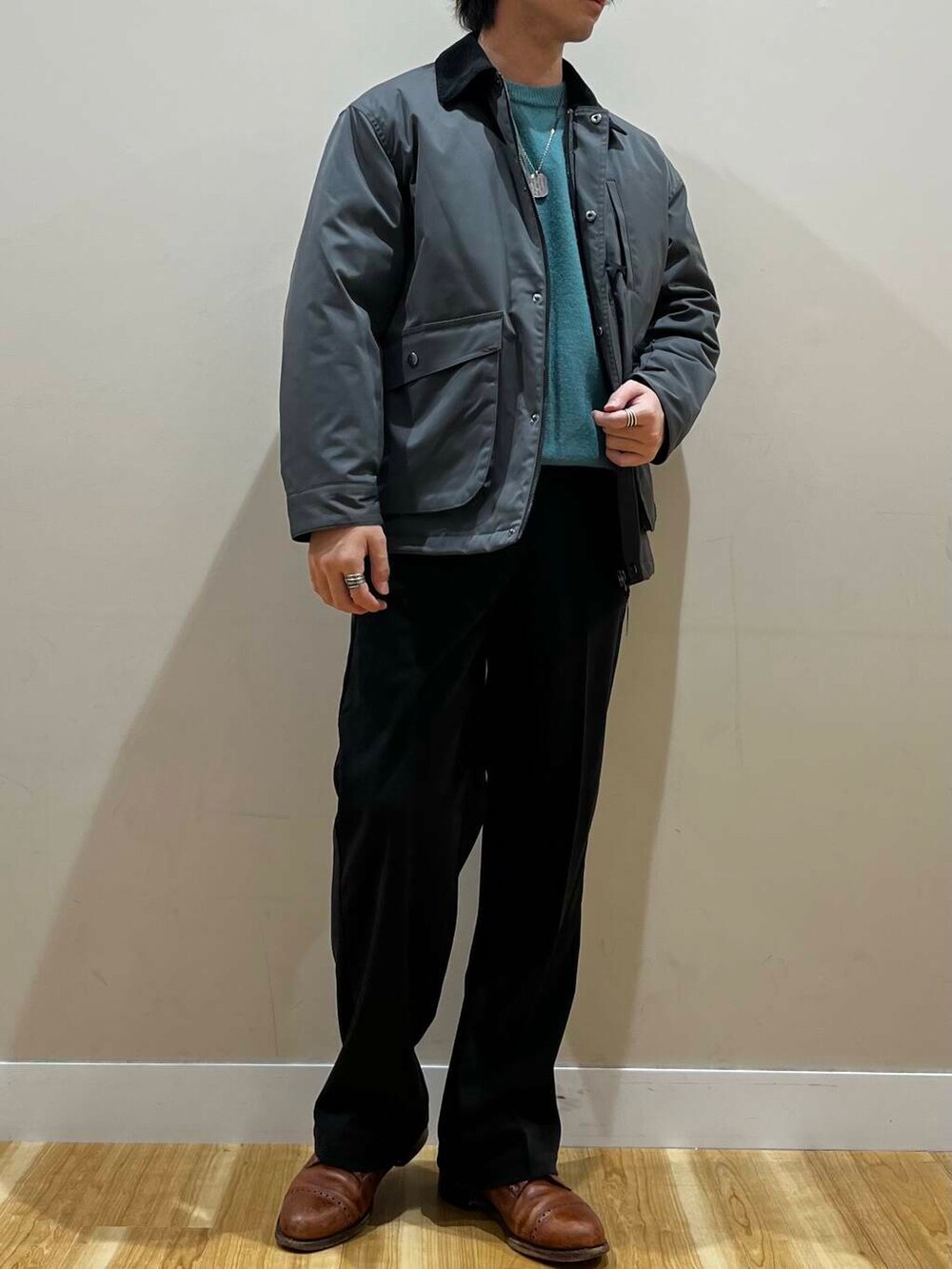 グリーン系のニット/セーター、グレー系のその他アウター、ブラック系のその他パンツを着用したメンズの秋コーディネートの3枚目の写真