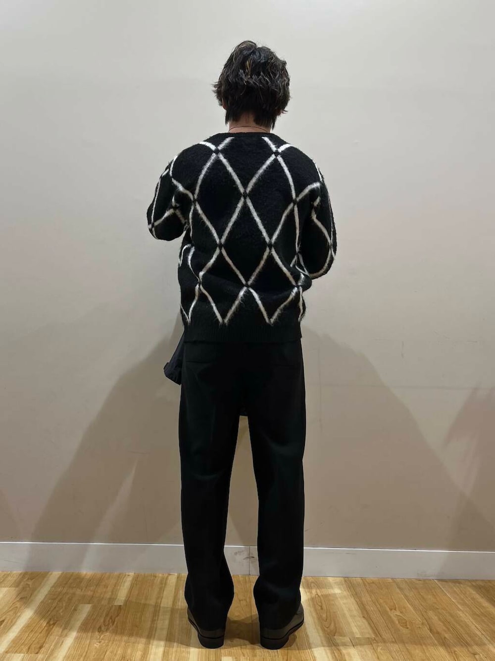 ブラック系のマウンテンパーカー、ブラック系のニット/セーター、ブラック系のその他パンツを着用したメンズの冬コーディネートの3枚目の写真