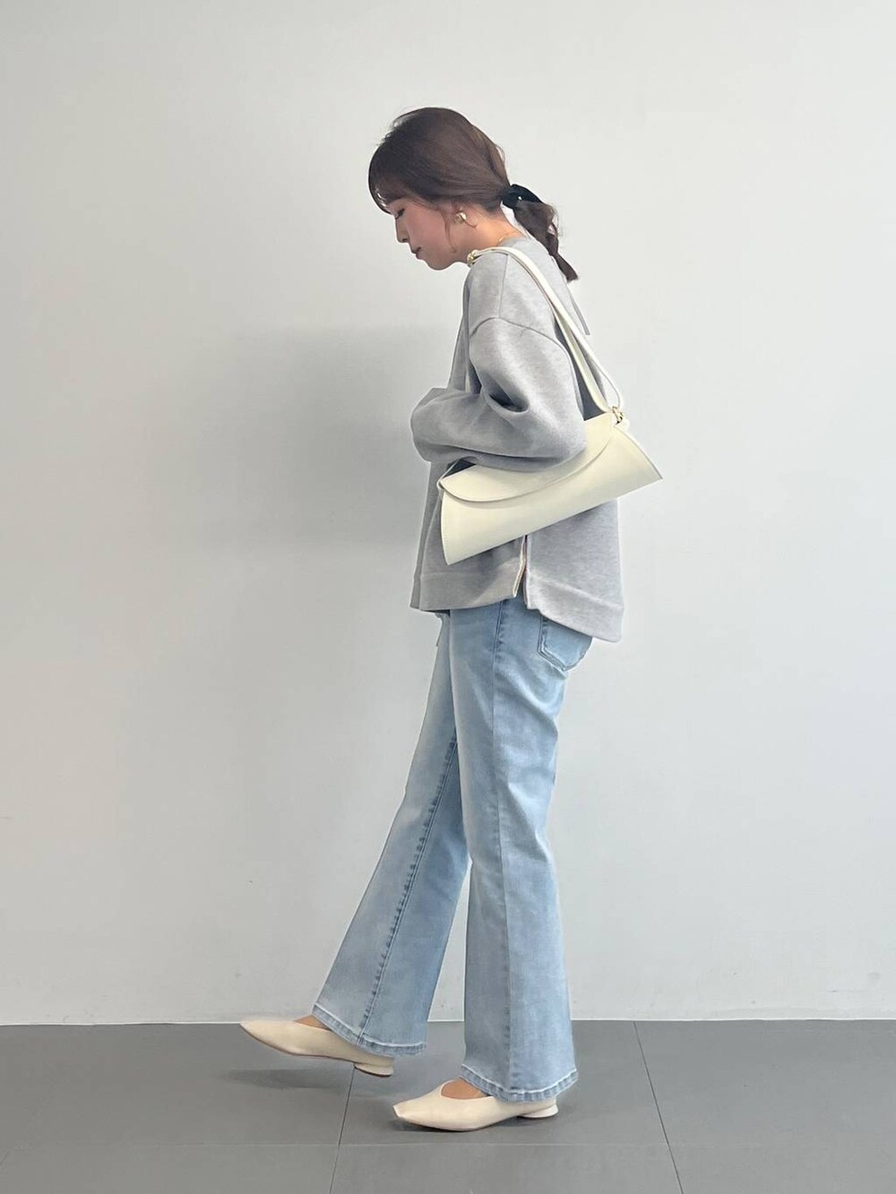 ホワイト系のショルダーバッグ、グレー系のスウェットを着用したレディースの冬コーディネートの5枚目の写真