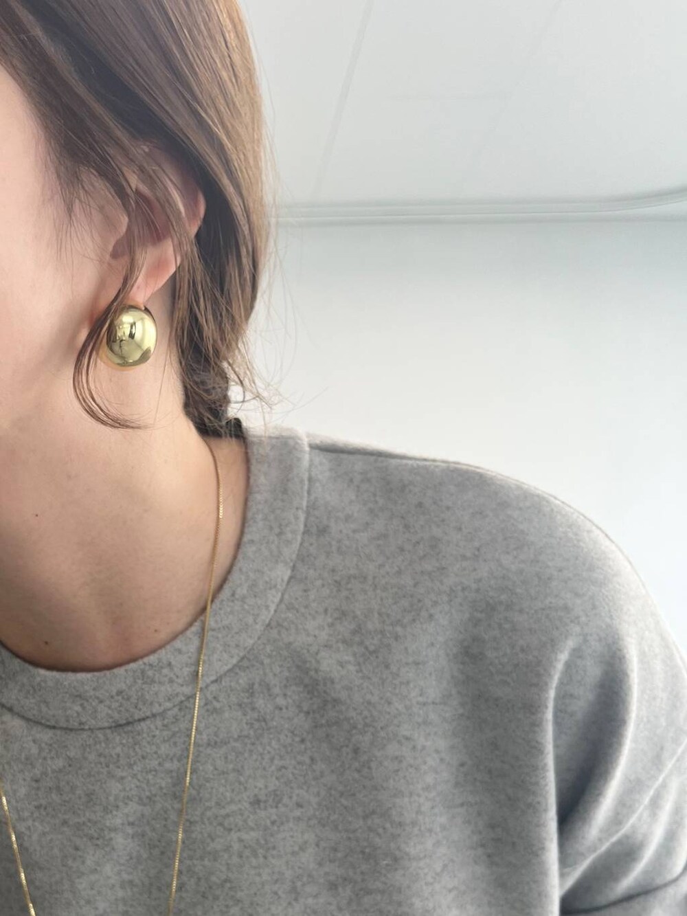 ホワイト系のショルダーバッグ、グレー系のスウェットを着用したレディースの冬コーディネートの7枚目の写真