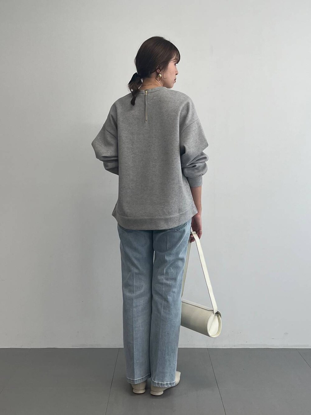 ホワイト系のショルダーバッグ、グレー系のスウェットを着用したレディースの冬コーディネートの4枚目の写真