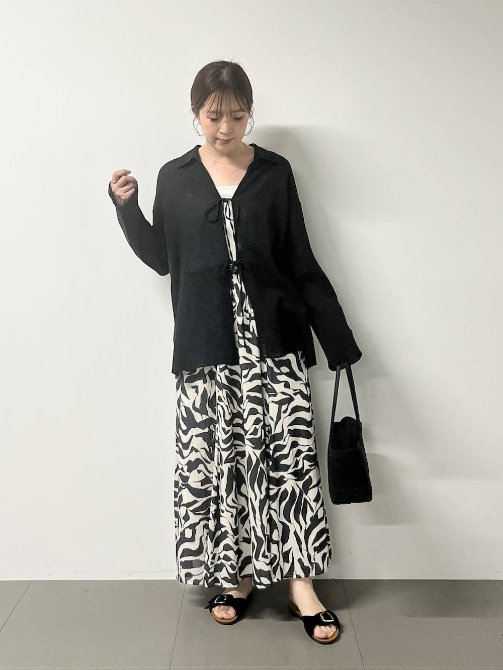 ホワイト系のキャミソール、ブラック系のシャツ/ブラウス、ブラック系のスカートを着用したレディースの春コーディネートの2枚目の写真