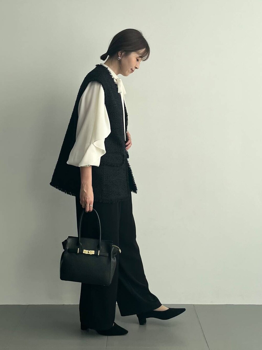 ブラック系のショルダーバッグ、ブラック系のその他パンツ、ホワイト系のシャツ/ブラウスを着用したレディースの冬コーディネートの3枚目の写真