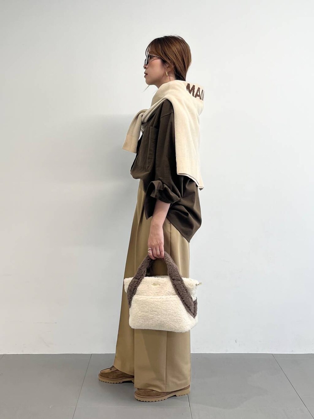 ホワイト系のトートバッグ、ベージュ系のローファー、イエロー系のスラックスを着用したレディースの秋コーディネートの3枚目の写真