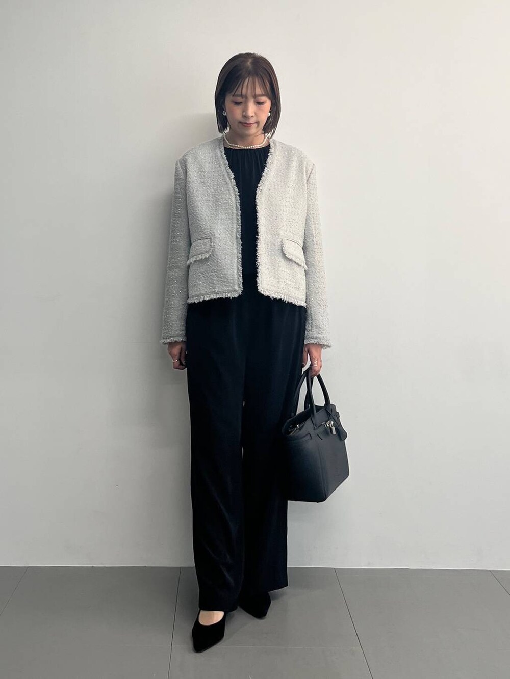 ブラック系のつなぎ/オールインワン、グレー系のノーカラージャケットを着用したレディースの冬コーディネートの3枚目の写真