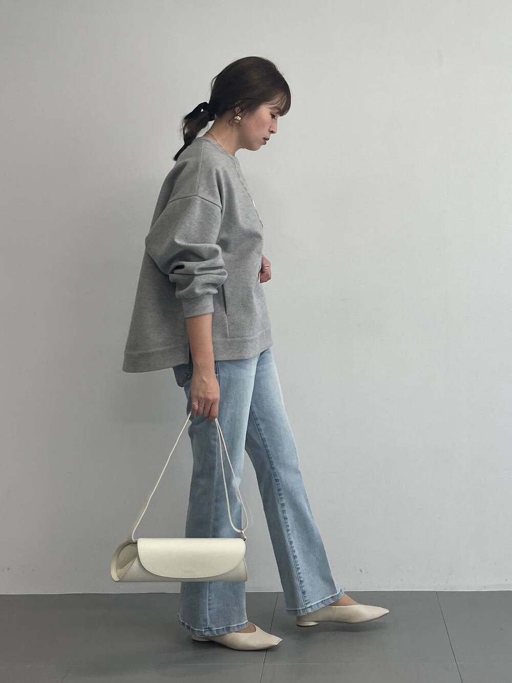 ホワイト系のショルダーバッグ、グレー系のスウェットを着用したレディースの冬コーディネートの3枚目の写真