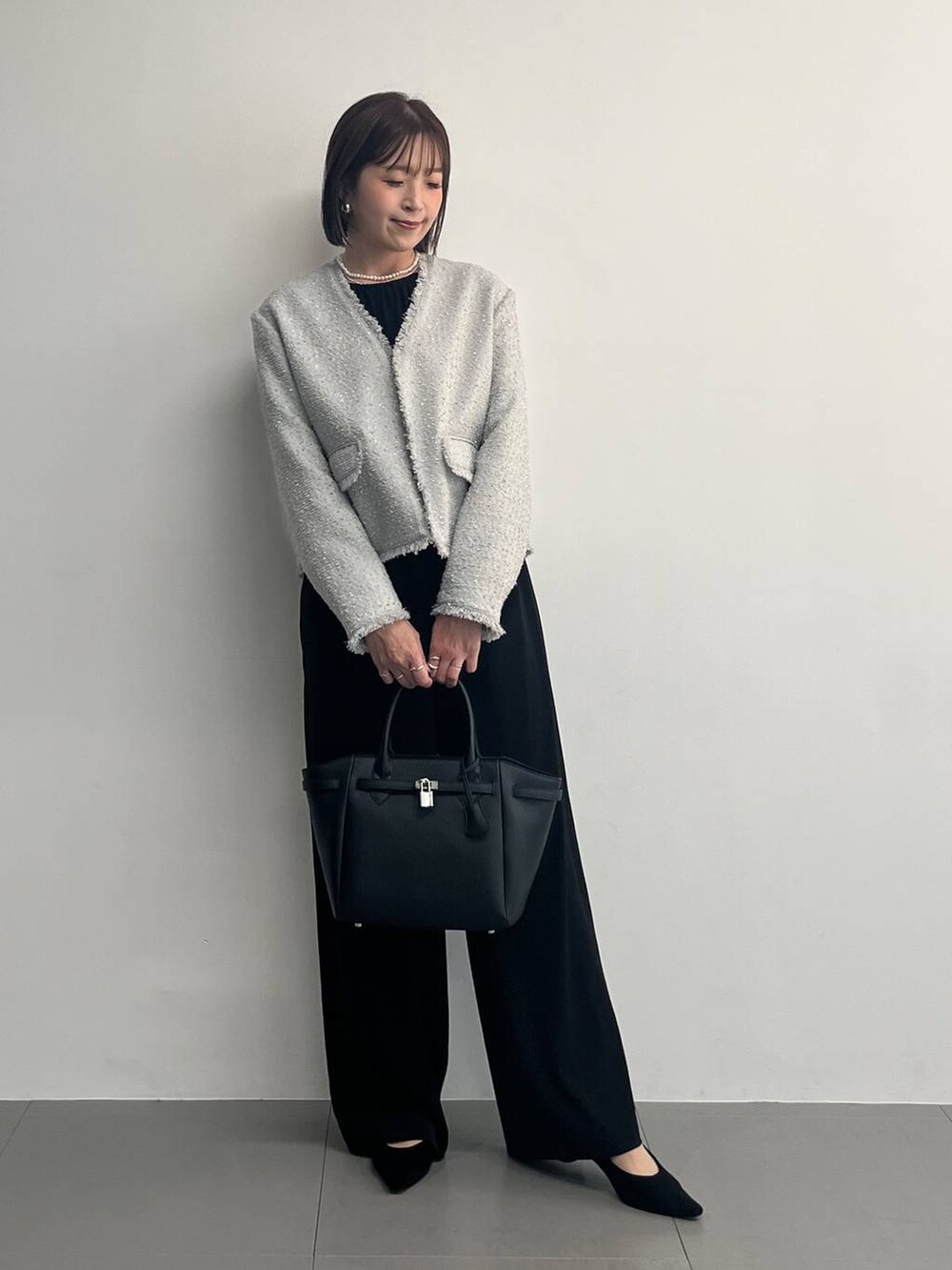 ブラック系のつなぎ/オールインワン、グレー系のノーカラージャケットを着用したレディースの冬コーディネートの2枚目の写真