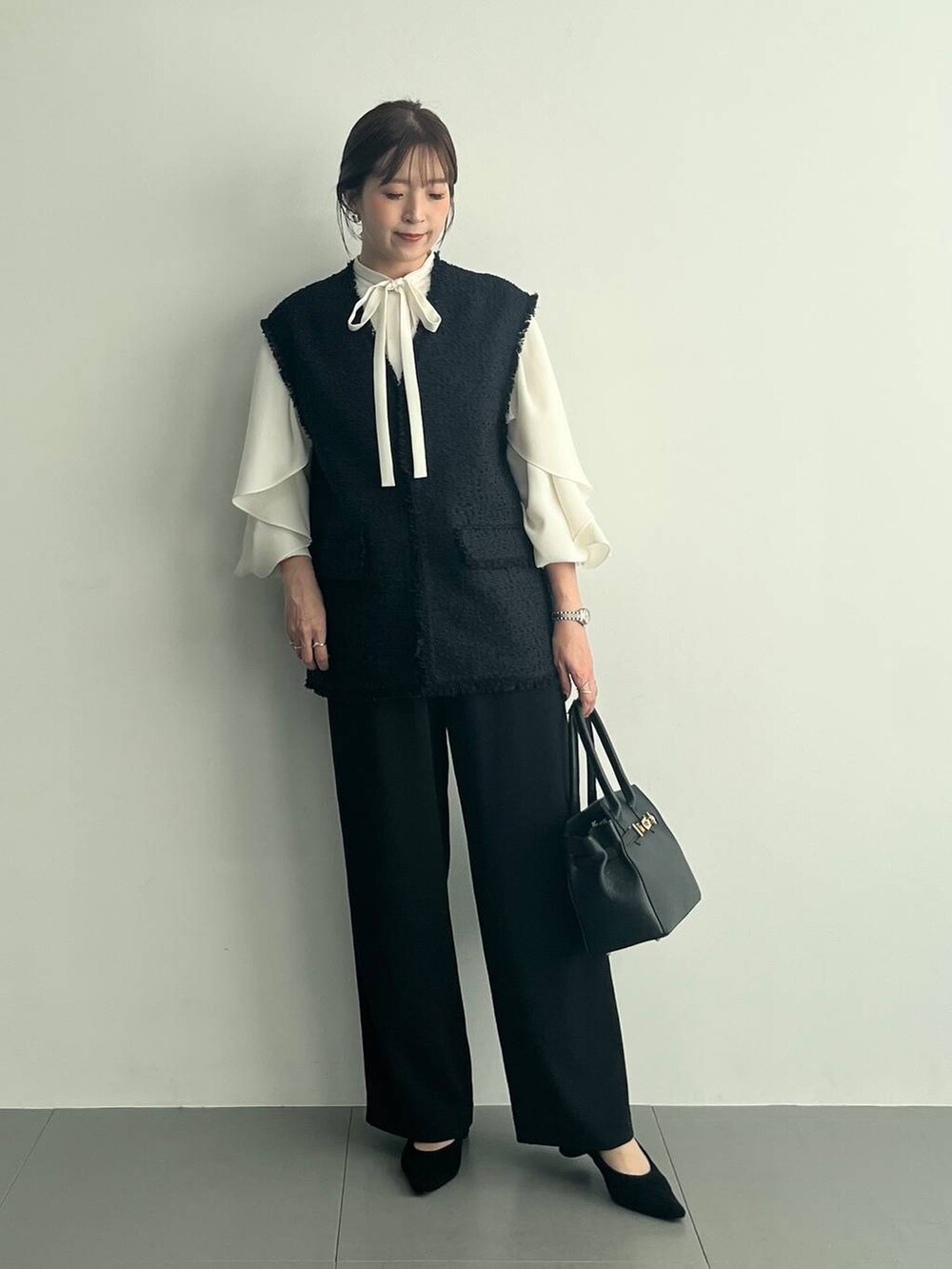 ブラック系のショルダーバッグ、ブラック系のその他パンツ、ホワイト系のシャツ/ブラウスを着用したレディースの冬コーディネートの2枚目の写真
