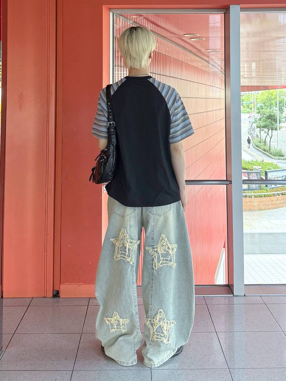 ブラック系のショルダーバッグ、ブルー系のデニムパンツ、ブラック系のTシャツ/カットソーを着用したメンズの夏コーディネートの3枚目の写真