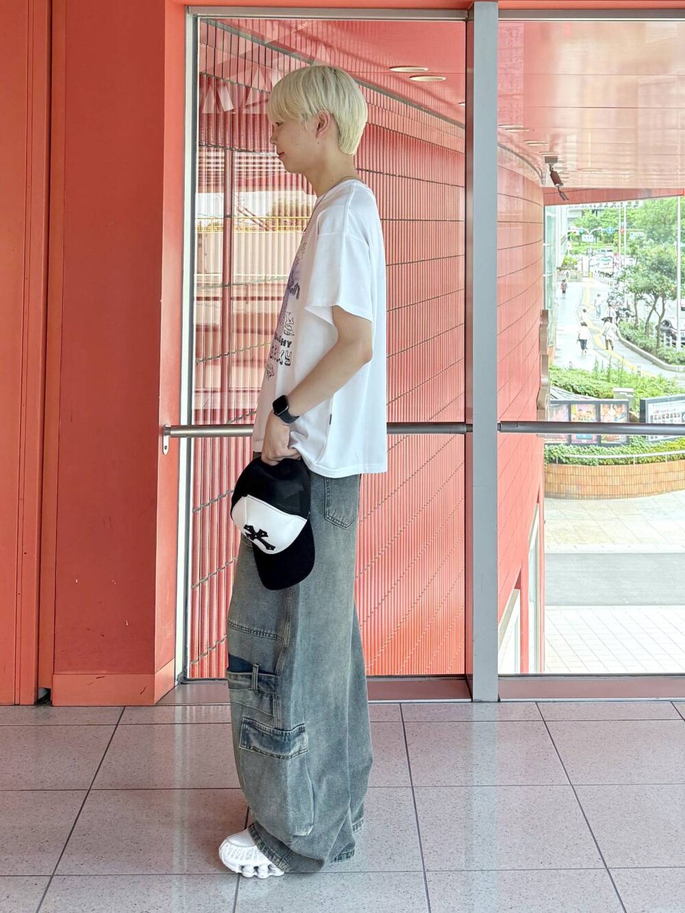 ホワイト系のTシャツ/カットソー、ブルー系のカーゴパンツ、ブラック系のキャップを着用したメンズの夏コーディネートの2枚目の写真