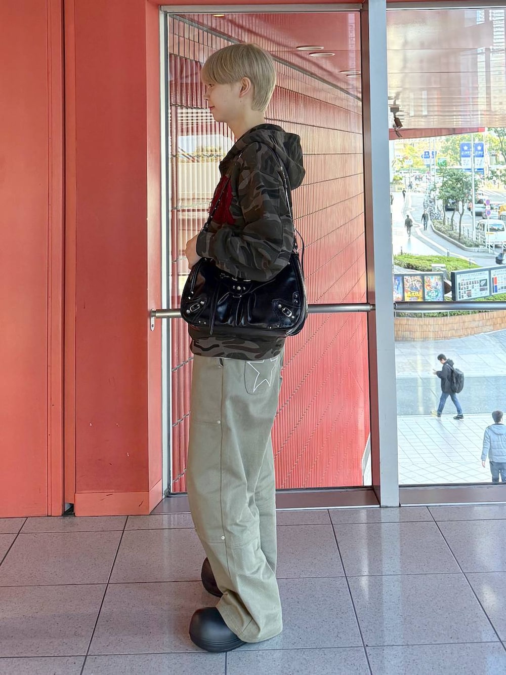 ブラック系のショルダーバッグ、ブラック系のスリッポン、グリーン系のその他パンツを着用したメンズの冬コーディネートの2枚目の写真