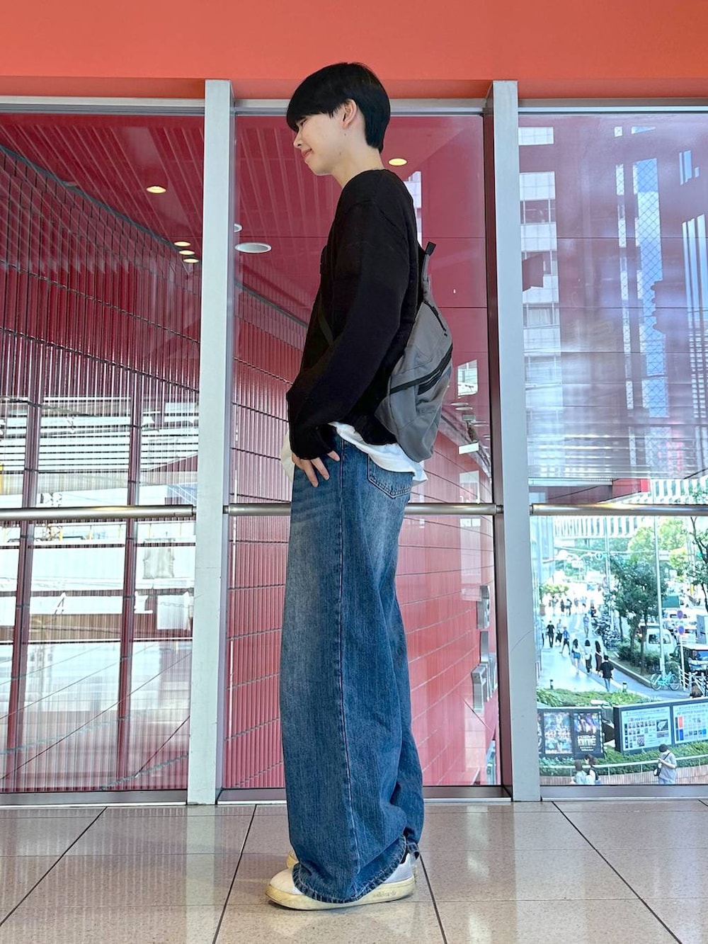 ブルー系のデニムパンツ、グレー系のバックパック/リュック、ブラック系のニット/セーターを着用したメンズの秋コーディネートの2枚目の写真