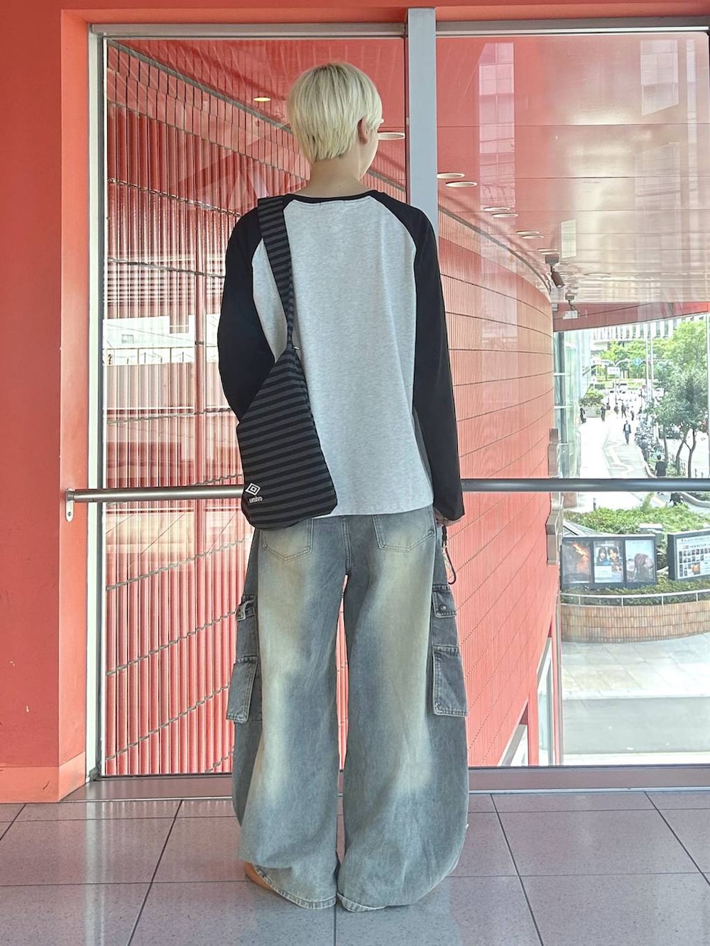 ブラック系のトートバッグ、ブラック系のTシャツ/カットソー、ブルー系のデニムパンツを着用したメンズの秋コーディネートの3枚目の写真