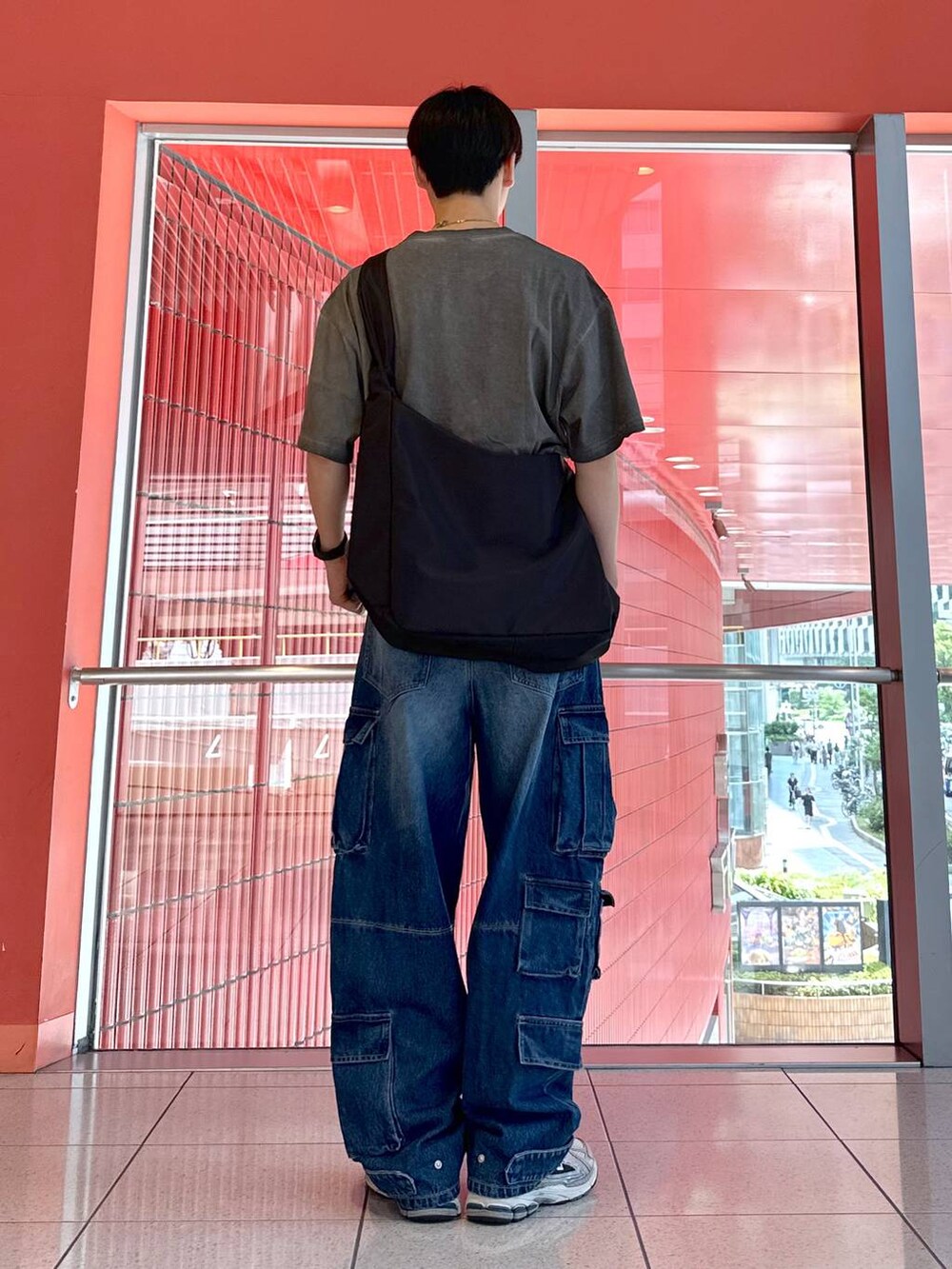 ブルー系のデニムパンツ、ブラック系のショルダーバッグ、グレー系のTシャツ/カットソーを着用したメンズの夏コーディネートの3枚目の写真