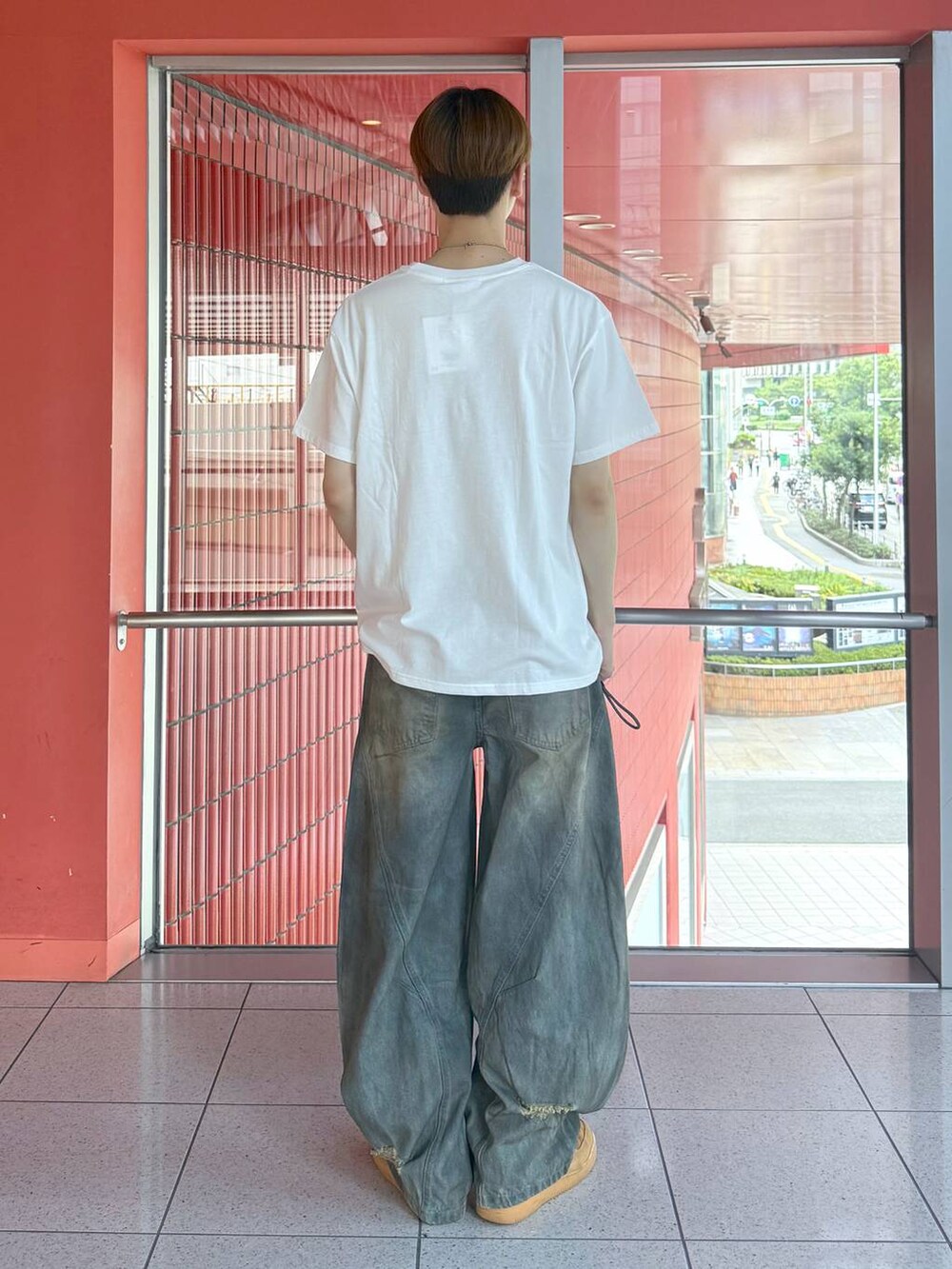 ブルー系のデニムパンツ、ホワイト系のTシャツ/カットソー、ブラック系のベルトを着用したメンズの夏コーディネートの3枚目の写真