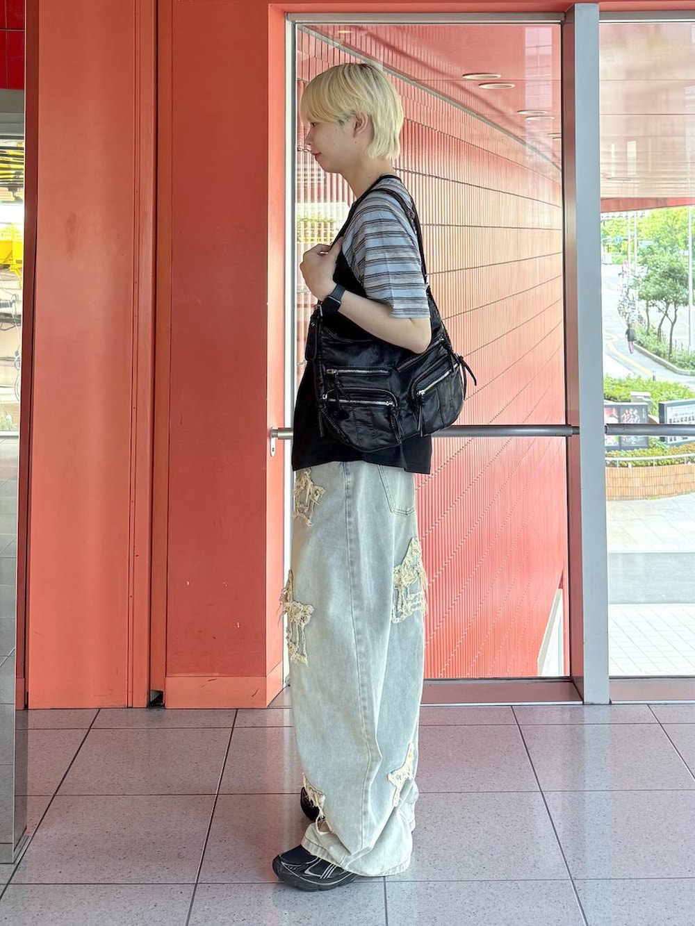 ブラック系のショルダーバッグ、ブルー系のデニムパンツ、ブラック系のTシャツ/カットソーを着用したメンズの夏コーディネートの2枚目の写真