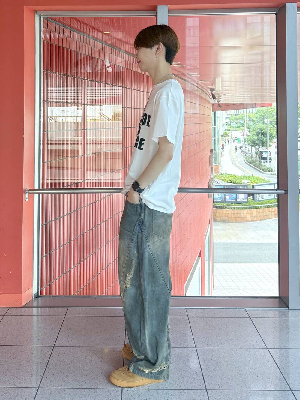 ブルー系のデニムパンツ、ホワイト系のTシャツ/カットソー、ブラック系のベルトを着用したメンズの夏コーディネートの2枚目の写真