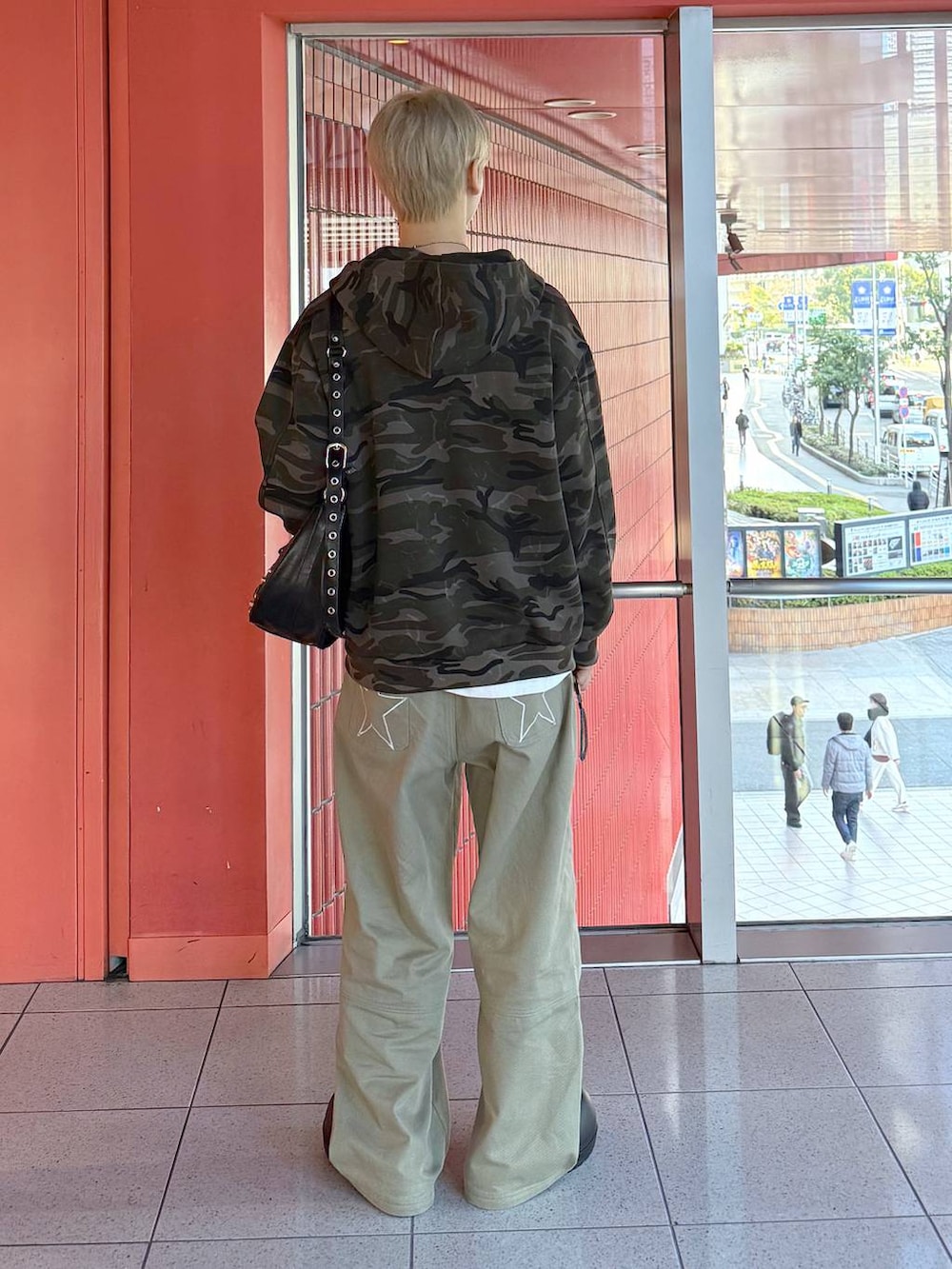 ブラック系のショルダーバッグ、ブラック系のスリッポン、グリーン系のその他パンツを着用したメンズの冬コーディネートの3枚目の写真