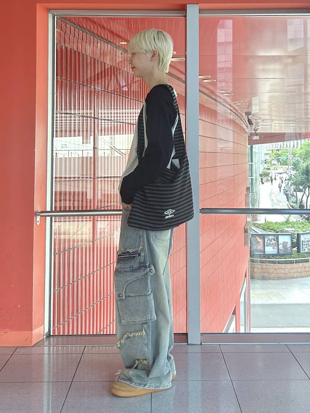 ブラック系のトートバッグ、ブラック系のTシャツ/カットソー、ブルー系のデニムパンツを着用したメンズの秋コーディネートの2枚目の写真