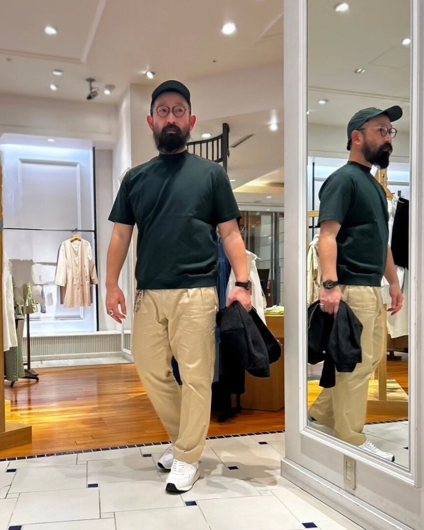 ブラック系のブルゾン、グリーン系のTシャツ/カットソー、ホワイト系のスニーカーを着用したメンズの春コーディネートの3枚目の写真