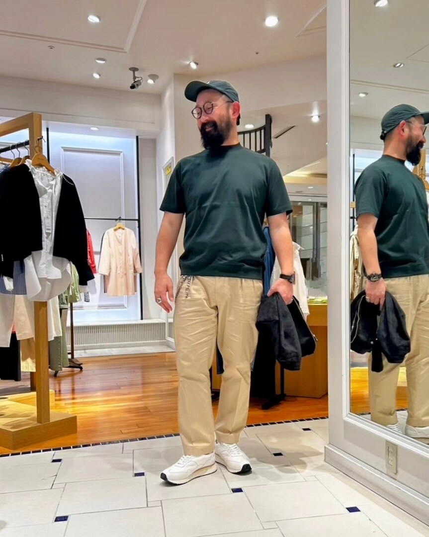 ブラック系のブルゾン、グリーン系のTシャツ/カットソー、ホワイト系のスニーカーを着用したメンズの春コーディネートの4枚目の写真