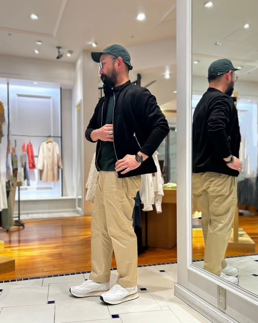 ブラック系のブルゾン、グリーン系のTシャツ/カットソー、ホワイト系のスニーカーを着用したメンズの春コーディネートの2枚目の写真