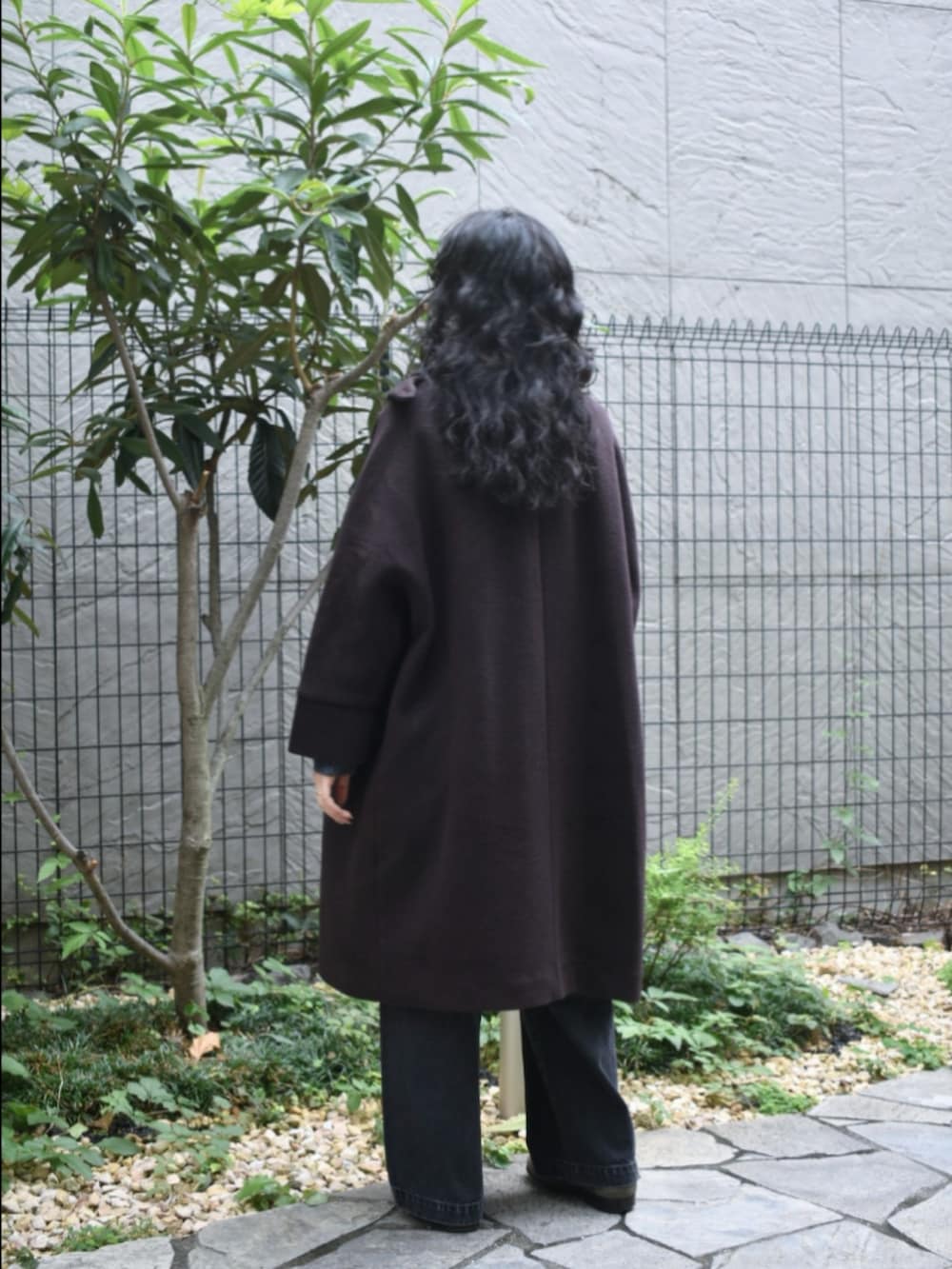 ブラウン系のテーラードジャケット、ブルー系のニット/セーター、ブラック系のデニムパンツを着用したレディースの秋コーディネートの4枚目の写真