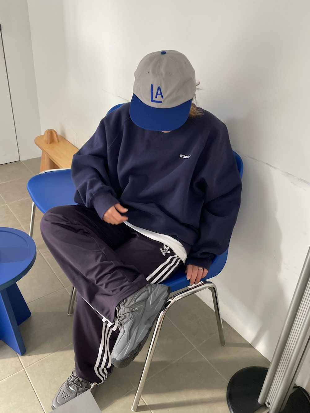 ブルー系のスウェット、ブルー系のスウェットパンツ、ブルー系のキャップを着用したレディースの冬コーディネートの2枚目の写真