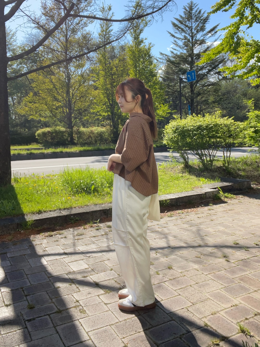 ホワイト系のスニーカー、ホワイト系のトートバッグ、ブラウン系のシャツ/ブラウスを着用したレディースの春コーディネートの4枚目の写真