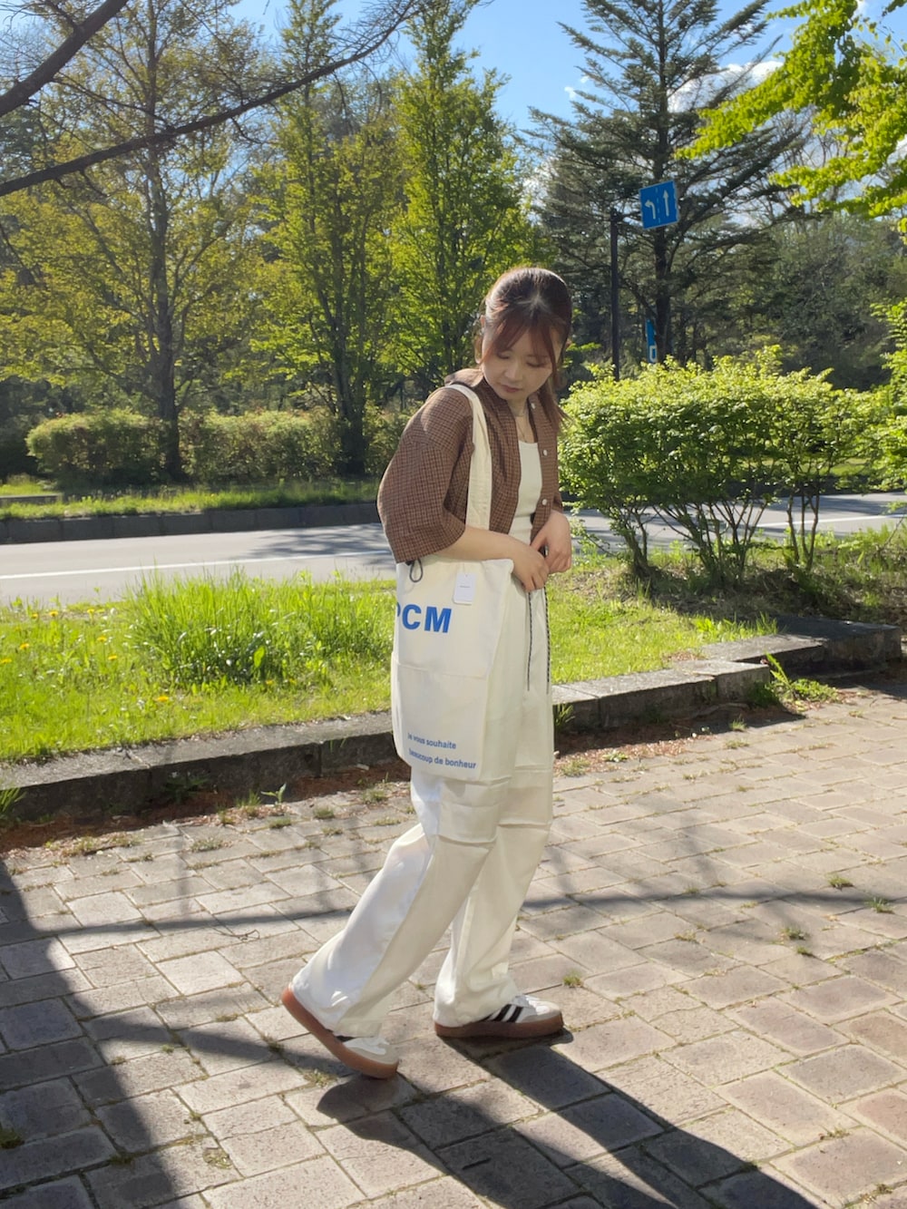 ホワイト系のスニーカー、ホワイト系のトートバッグ、ブラウン系のシャツ/ブラウスを着用したレディースの春コーディネートの3枚目の写真