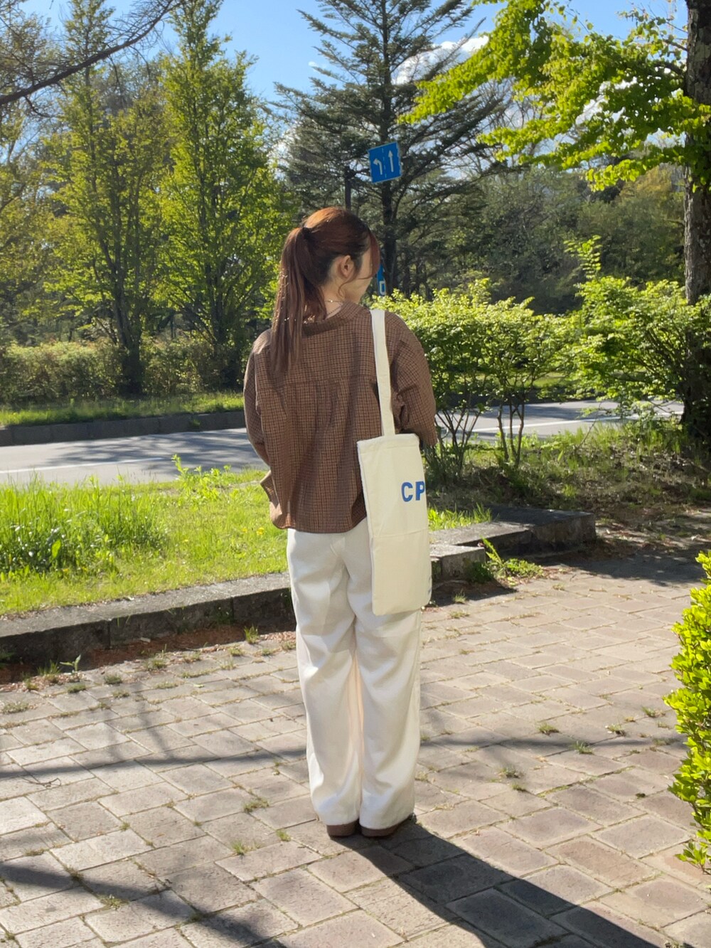 ホワイト系のスニーカー、ホワイト系のトートバッグ、ブラウン系のシャツ/ブラウスを着用したレディースの春コーディネートの2枚目の写真