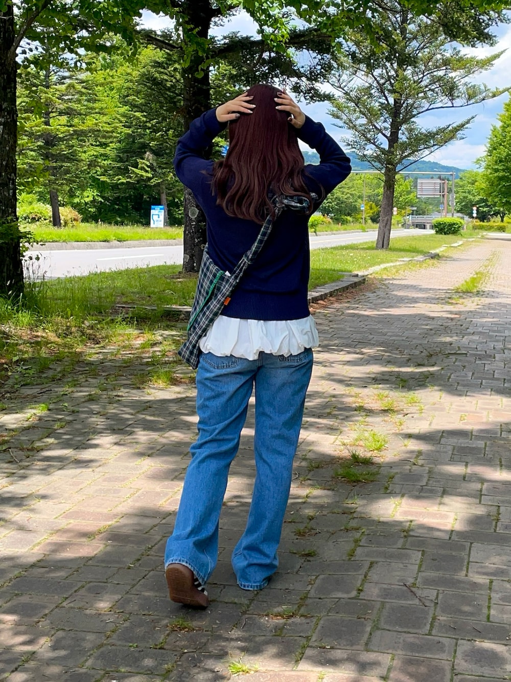 ホワイト系のスニーカー、ブルー系のショルダーバッグ、ブルー系のカーディガン/ボレロを着用したレディースの春コーディネートの3枚目の写真