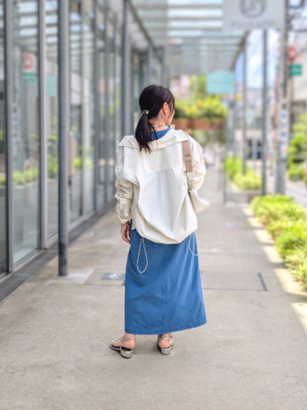 ブルー系のワンピース、イエロー系のシャツ/ブラウス、シルバー系のサンダルを着用したレディースの夏コーディネートの3枚目の写真