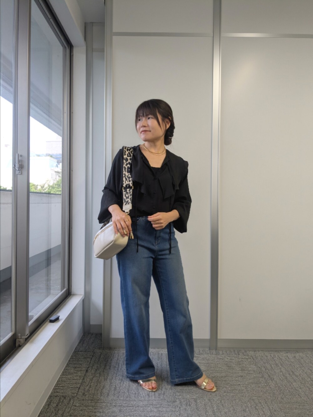 ブラック系のシャツ/ブラウス、ブルー系のデニムパンツ、ゴールド系のサンダルを着用したレディースの夏コーディネートの2枚目の写真