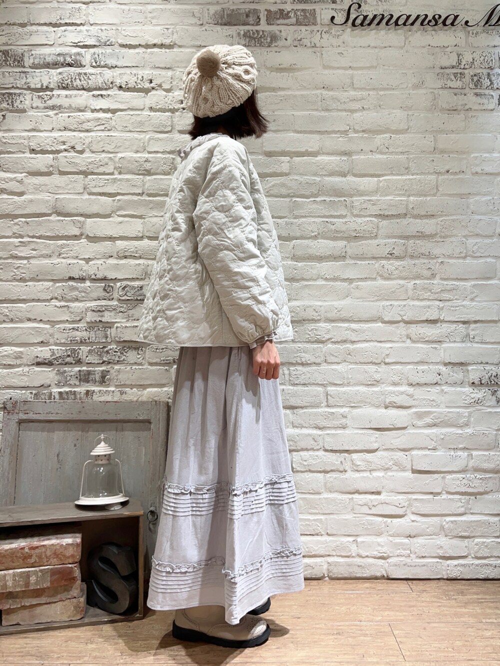 ホワイト系のノーカラージャケット、グレー系のシャツ/ブラウス、ブルー系のスカートを着用したレディースの冬コーディネートの4枚目の写真