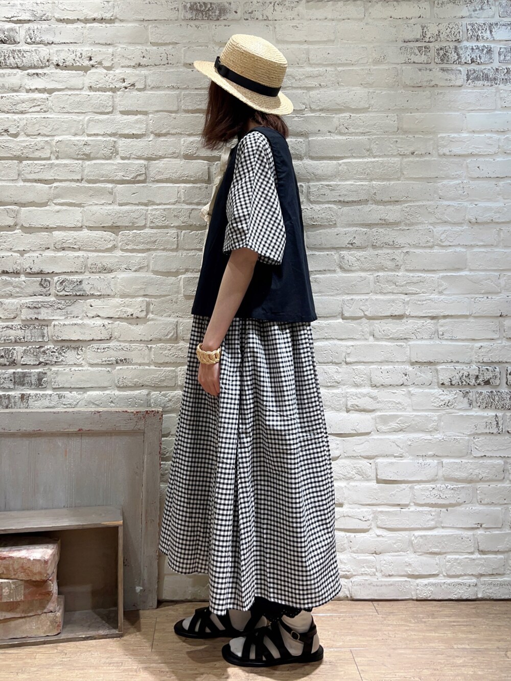 ブラック系のベスト、ブラック系のハンドバッグ、ホワイト系のワンピースを着用したレディースの秋コーディネートの2枚目の写真