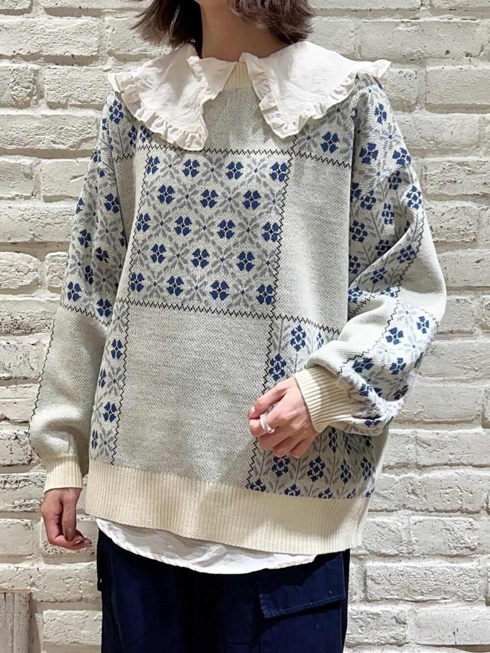 ホワイト系のシャツ/ブラウス、ホワイト系のニット/セーター、ブルー系のカーゴパンツを着用したレディースの冬コーディネートの2枚目の写真