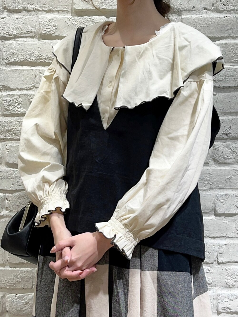 ホワイト系のTシャツ/カットソー、グレー系のTシャツ/カットソー、ブラック系のベストを着用したレディースの秋コーディネートの2枚目の写真