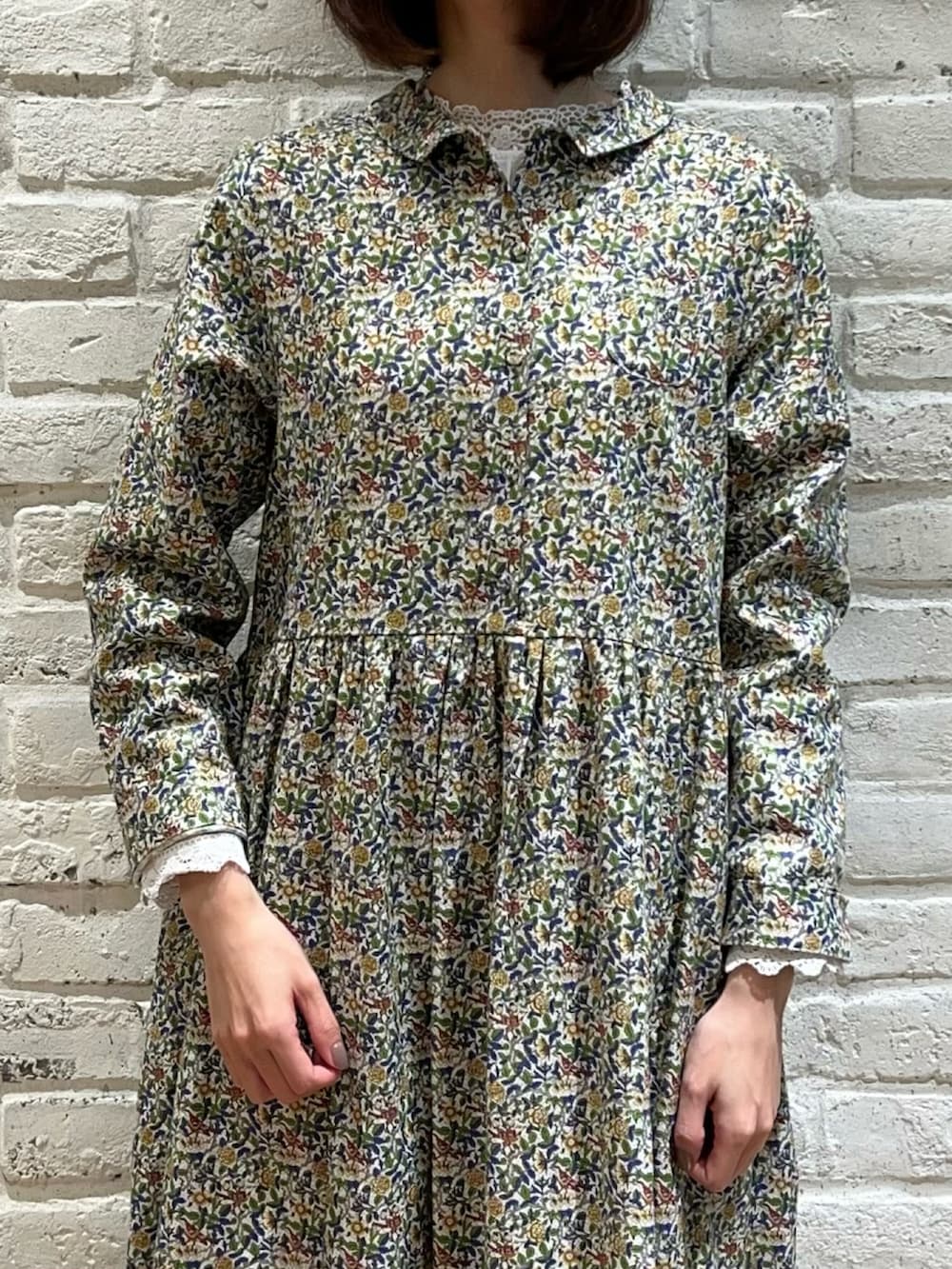 ホワイト系のトップス、ブルー系のワンピース、ベージュ系のドレスシューズを着用したレディースの冬コーディネートの3枚目の写真