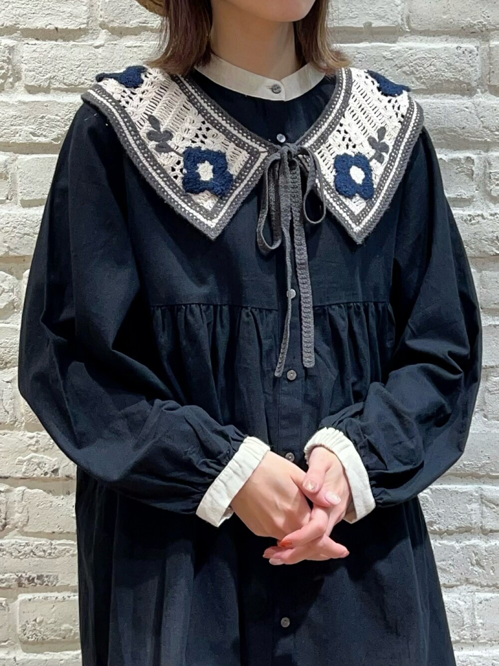 ブラック系のチュニック、ホワイト系のハンドバッグ、ホワイト系のその他パンツを着用したレディースの春コーディネートの2枚目の写真