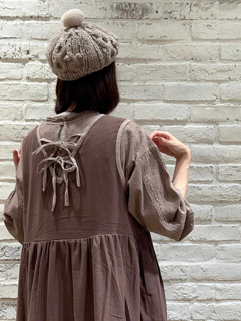 ブラウン系のワンピース、ブラウン系のワンピース、ブラウン系のハンドバッグを着用したレディースの冬コーディネートの5枚目の写真