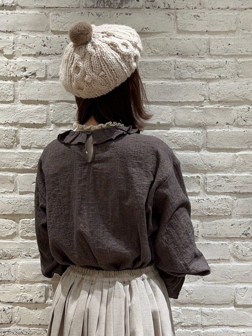 ホワイト系のニット/セーター、ベージュ系のカーディガン/ボレロ、グレー系のシャツ/ブラウスを着用したレディースの冬コーディネートの5枚目の写真