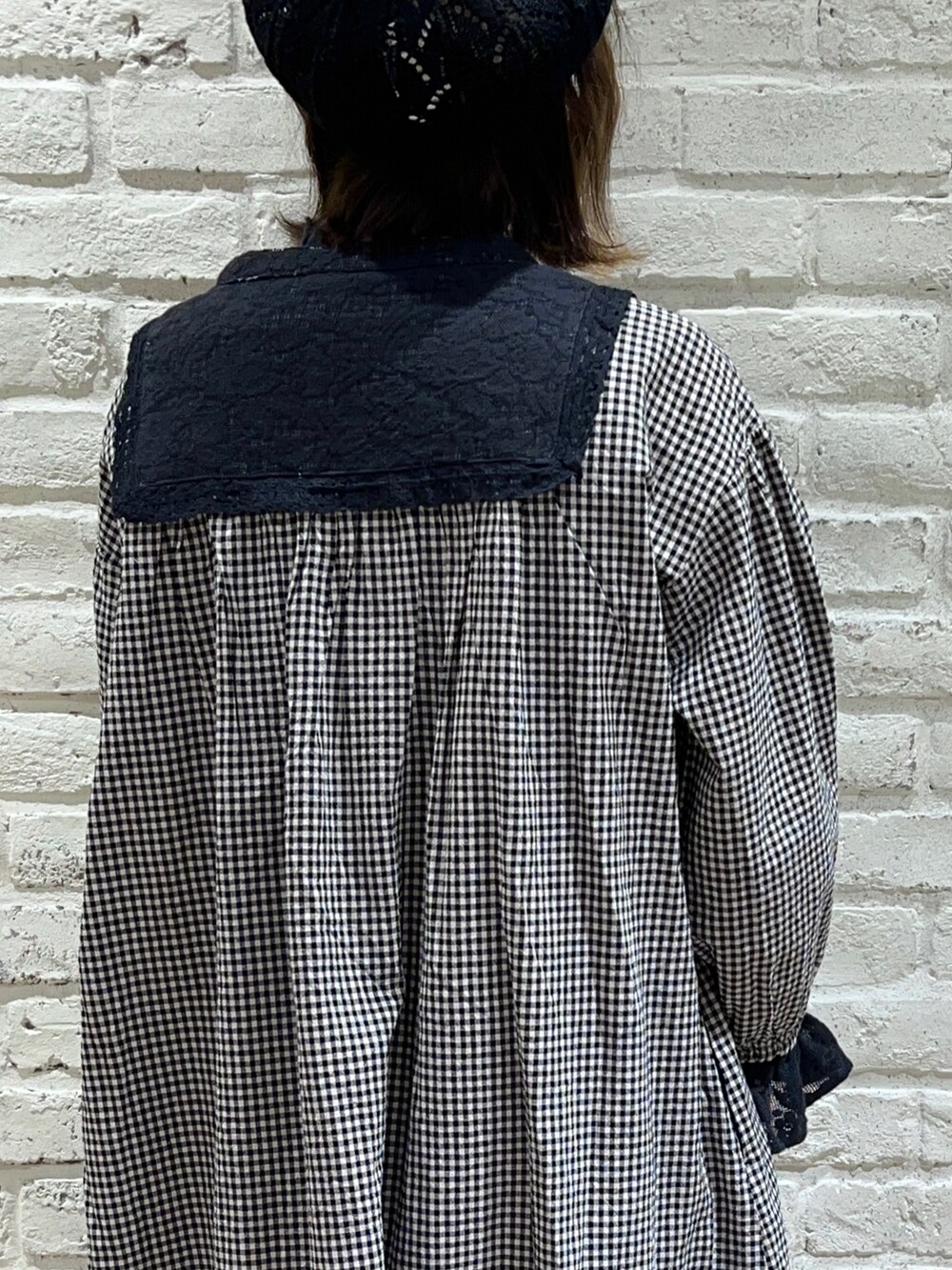 ブラック系のシャツ/ブラウス、ホワイト系のカーディガン/ボレロ、ブラック系のドレスシューズを着用したレディースの冬コーディネートの5枚目の写真