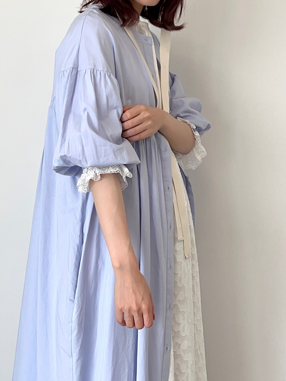 パープル系のワンピース、ホワイト系のワンピース、ホワイト系のサンダルを着用したレディースの春コーディネートの2枚目の写真