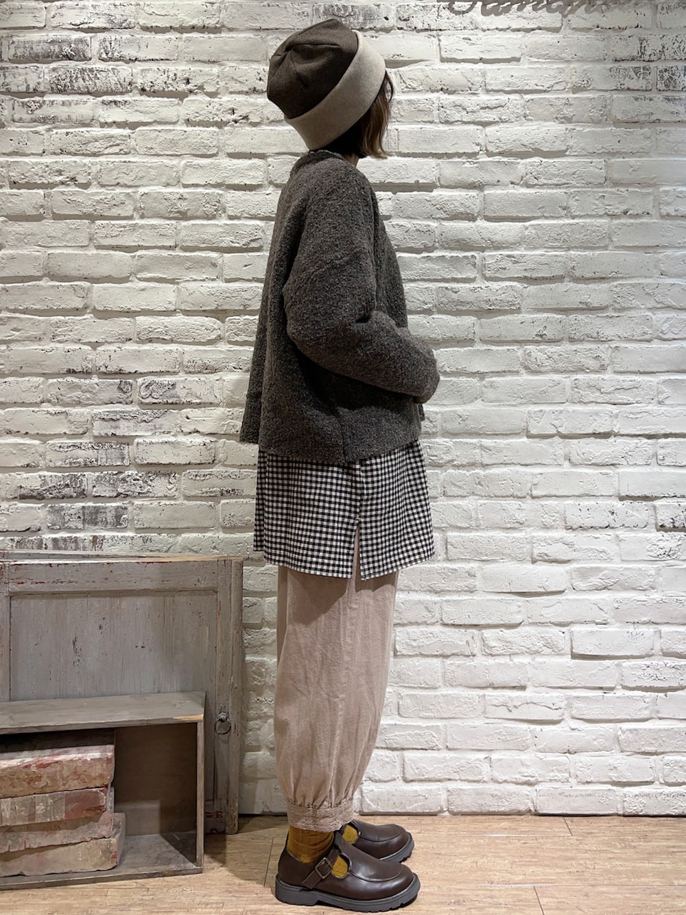 ホワイト系のTシャツ/カットソー、ブラウン系のカーディガン/ボレロ、ブラック系のチュニックを着用したレディースの秋コーディネートの3枚目の写真