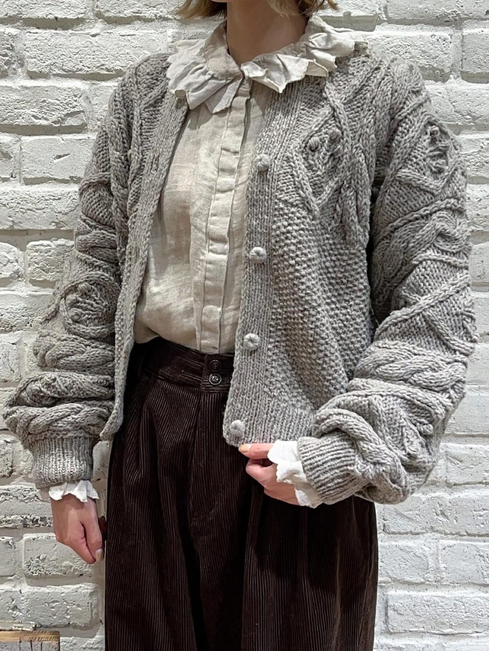 ホワイト系のシャツ/ブラウス、ブラウン系のカーディガン/ボレロ、ブラウン系のその他パンツを着用したレディースの秋コーディネートの2枚目の写真