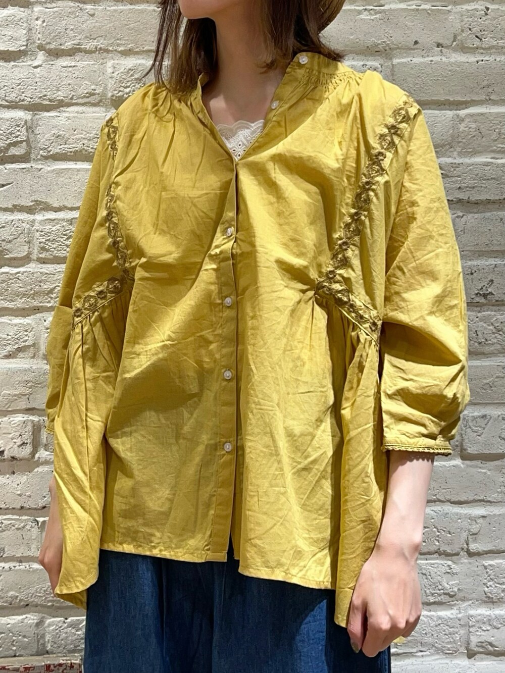 ホワイト系のタンクトップ、イエロー系のシャツ/ブラウス、ブラック系のハンドバッグを着用したレディースの夏コーディネートの2枚目の写真