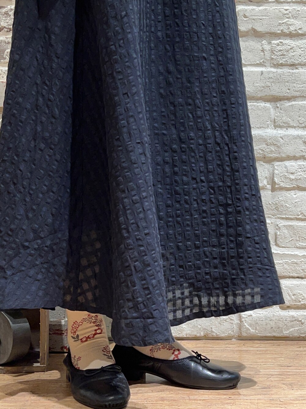 イエロー系のチュニック、ブラック系のスカート、ブラック系のハットを着用したレディースの秋コーディネートの5枚目の写真